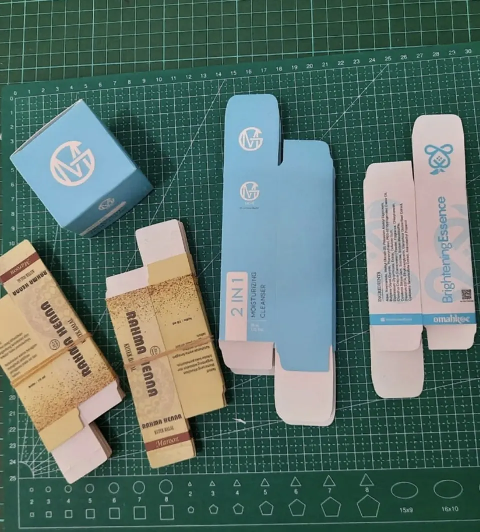 Contoh box kosmetik terlipat dan pola box custom di atas meja potong